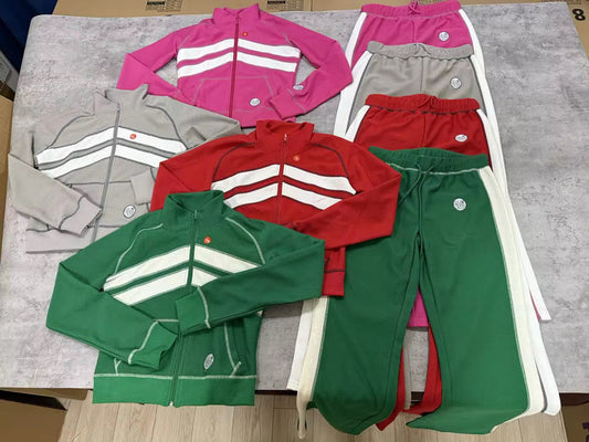 Collection of green, red, and pink tracksuits on a flat surface.
